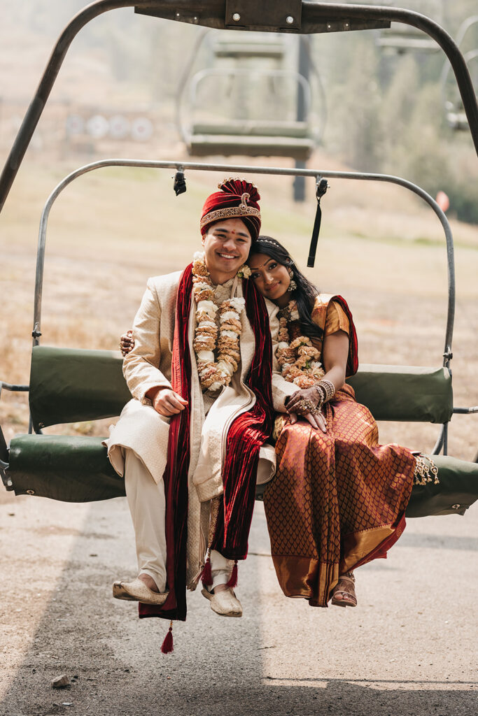 man and woman dressed in traditional Indian attire sitting on a chairlift